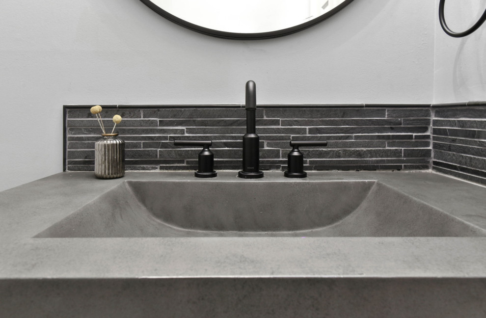 Inspiration for a cottage limestone tile powder room remodel in Chicago with an integrated sink, concrete countertops and gray countertops