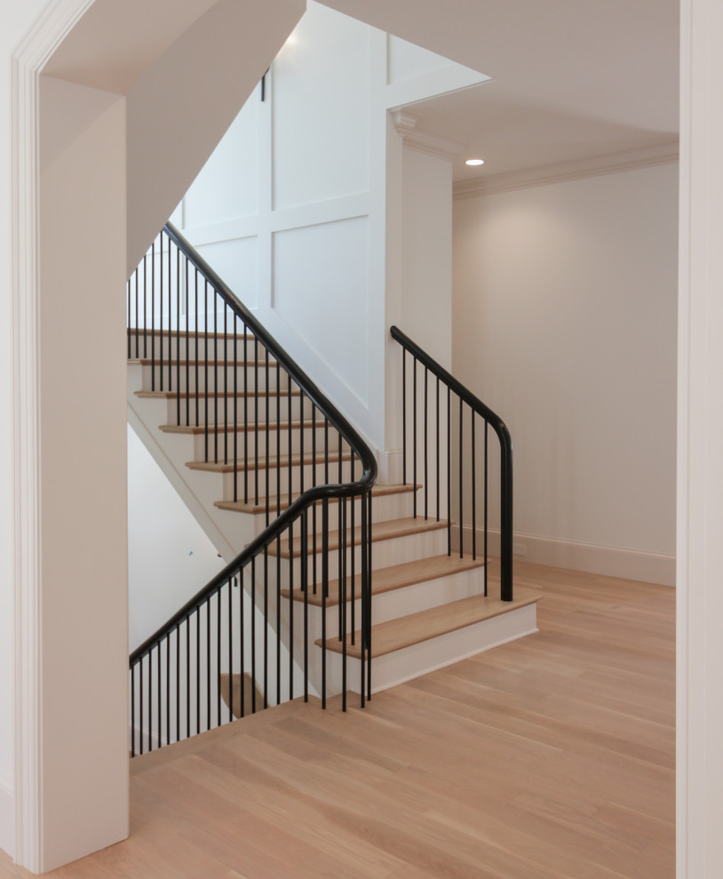 Свежая идея для дизайна: большая п-образная лестница в стиле модернизм с деревянными ступенями, крашенными деревянными подступенками, перилами из смешанных материалов и панелями на стенах - отличное фото интерьера