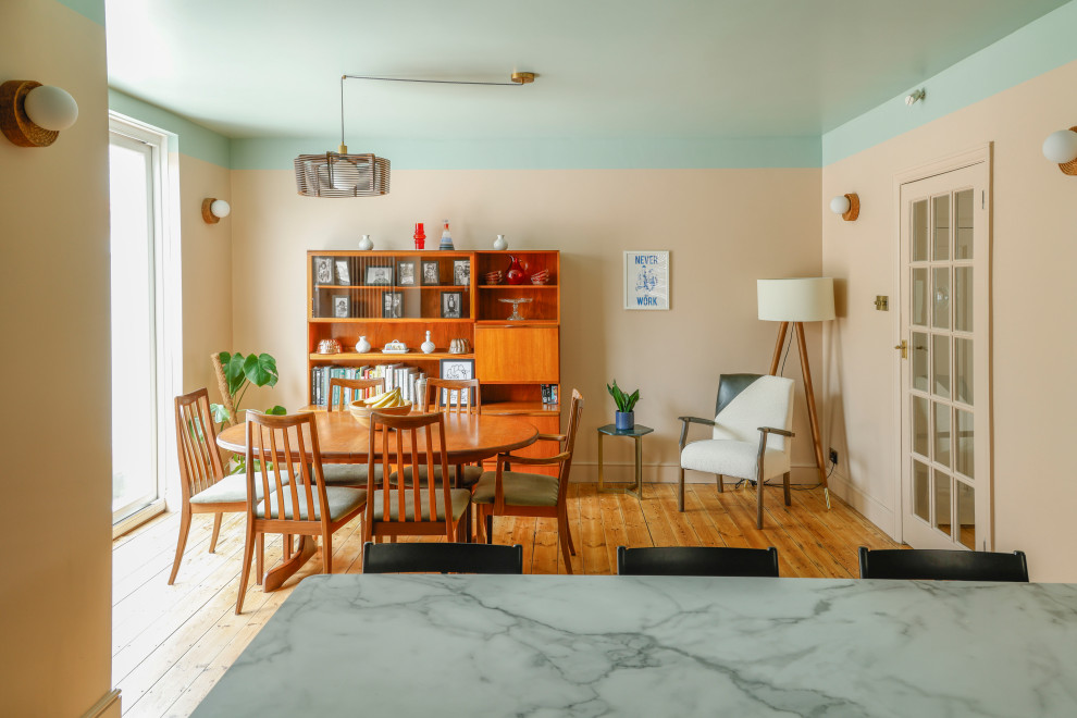 This is an example of a medium sized contemporary kitchen/dining room in Kent with pink walls, exposed beams and feature lighting.