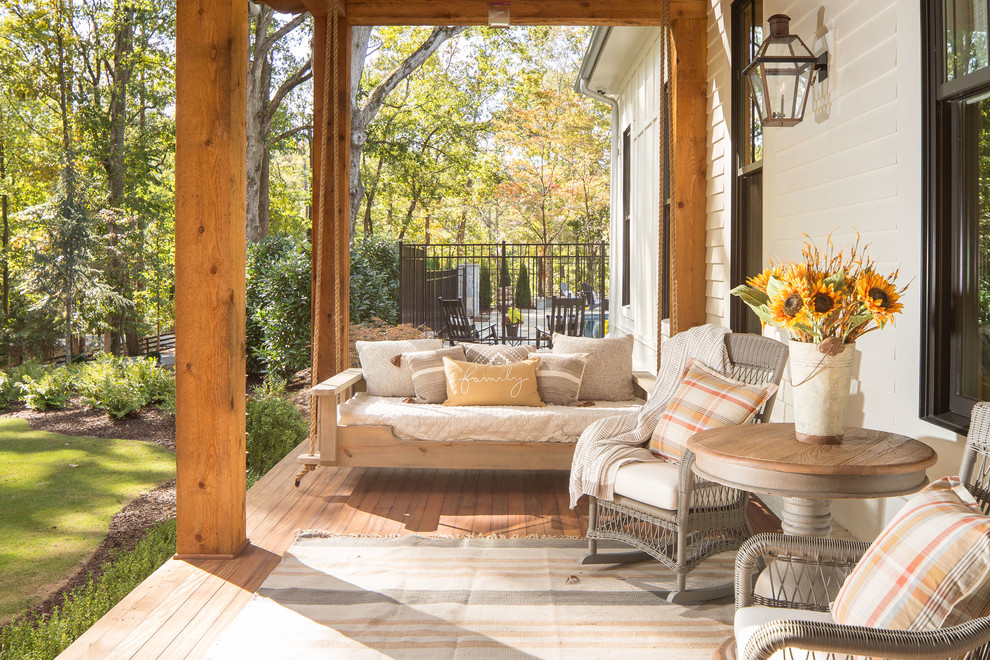 This is an example of an expansive country front yard verandah in Atlanta with decking and a roof extension.