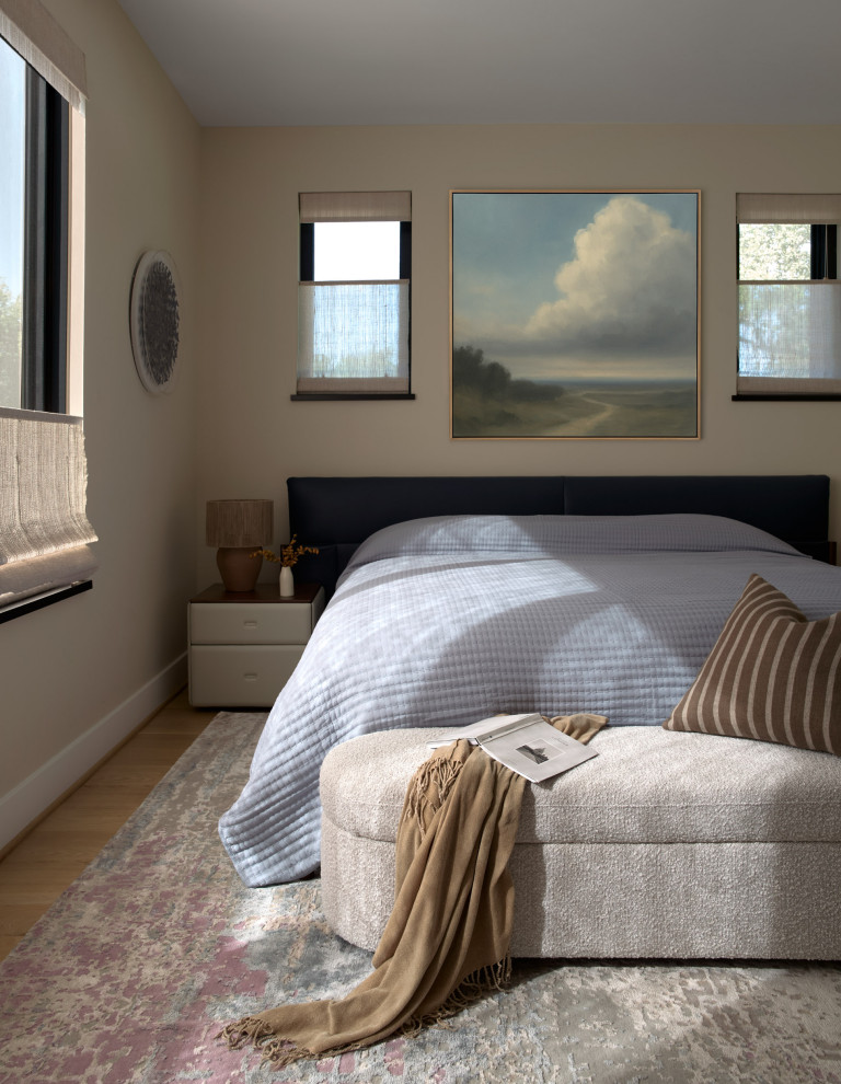 Example of a trendy medium tone wood floor and brown floor bedroom design with beige walls