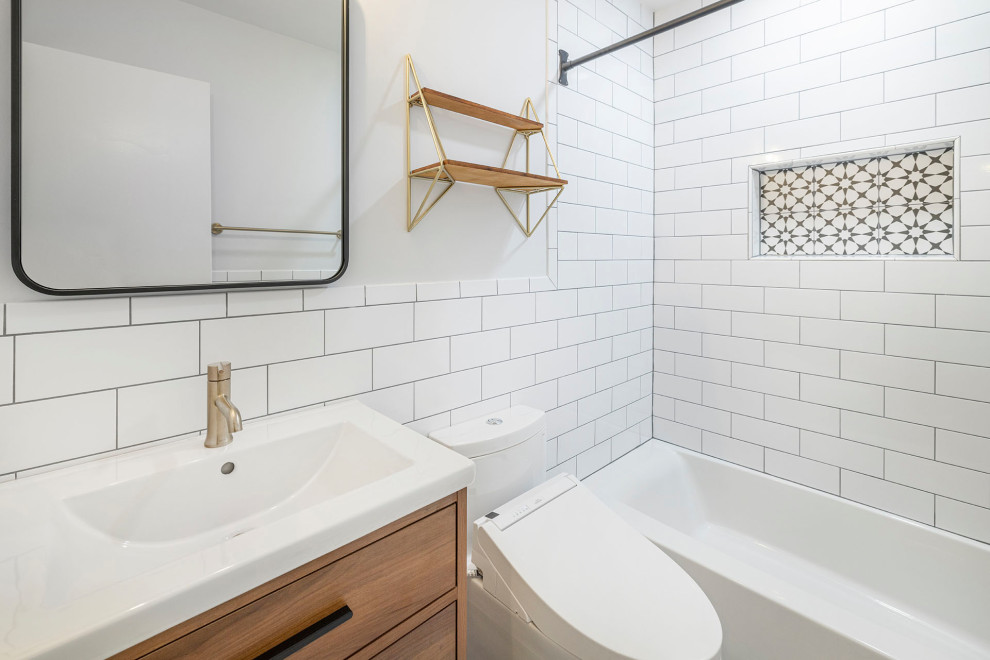 Источник вдохновения для домашнего уюта: маленькая главная ванная комната в стиле ретро с плоскими фасадами, душем над ванной, унитазом-моноблоком, белой плиткой, керамической плиткой, серыми стенами, монолитной раковиной, столешницей из искусственного камня, разноцветным полом, шторкой для ванной, белой столешницей, нишей, тумбой под одну раковину, напольной тумбой, фасадами цвета дерева среднего тона, ванной в нише и полом из керамогранита для на участке и в саду