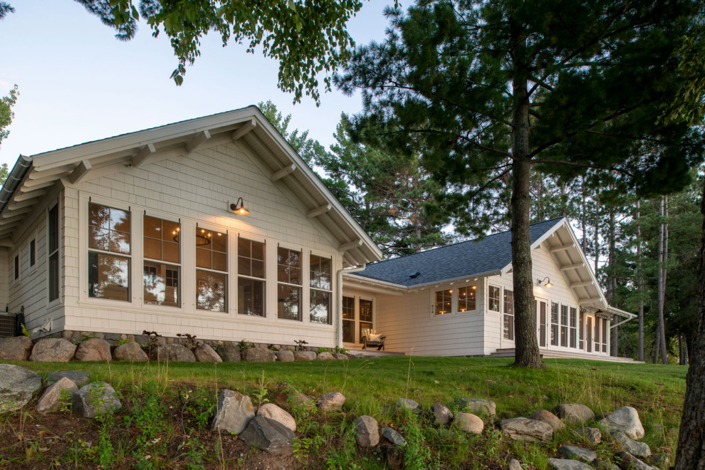 This is an example of a mid-sized beach style one-storey white house exterior in Minneapolis with wood siding, a shingle roof, a black roof and shingle siding.