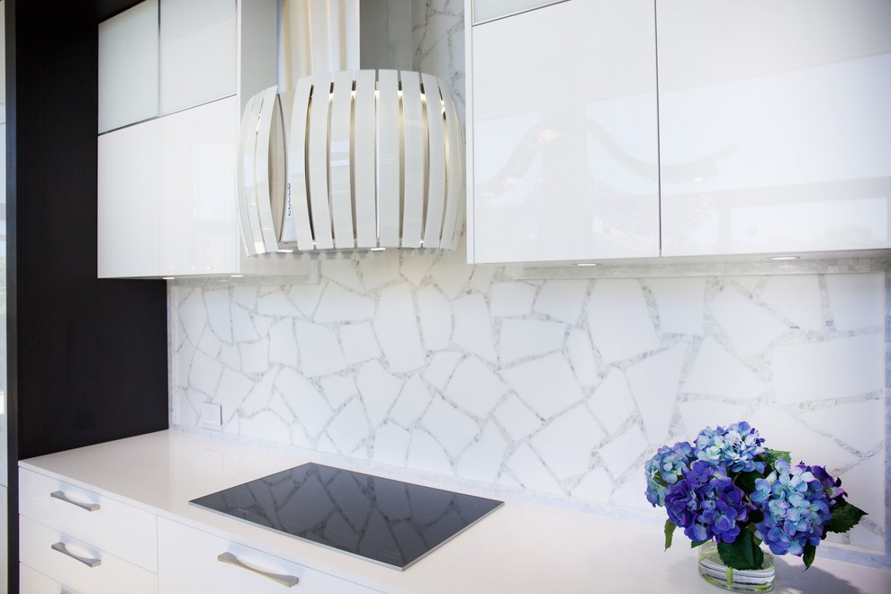 Photo of a large single-wall eat-in kitchen in Miami with a single-bowl sink, flat-panel cabinets, white cabinets, quartz benchtops, white splashback, mosaic tile splashback, panelled appliances and with island.