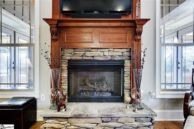 Photo of a large arts and crafts formal enclosed living room in Other with grey walls, medium hardwood floors, a standard fireplace, a stone fireplace surround and a built-in media wall.