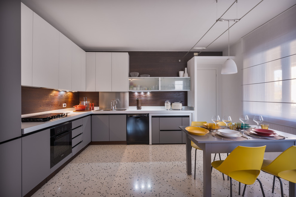 Design ideas for a mid-sized contemporary l-shaped eat-in kitchen in Venice with a double-bowl sink, flat-panel cabinets, beige cabinets, laminate benchtops, metallic splashback, black appliances, terrazzo floors, no island, white floor and beige benchtop.