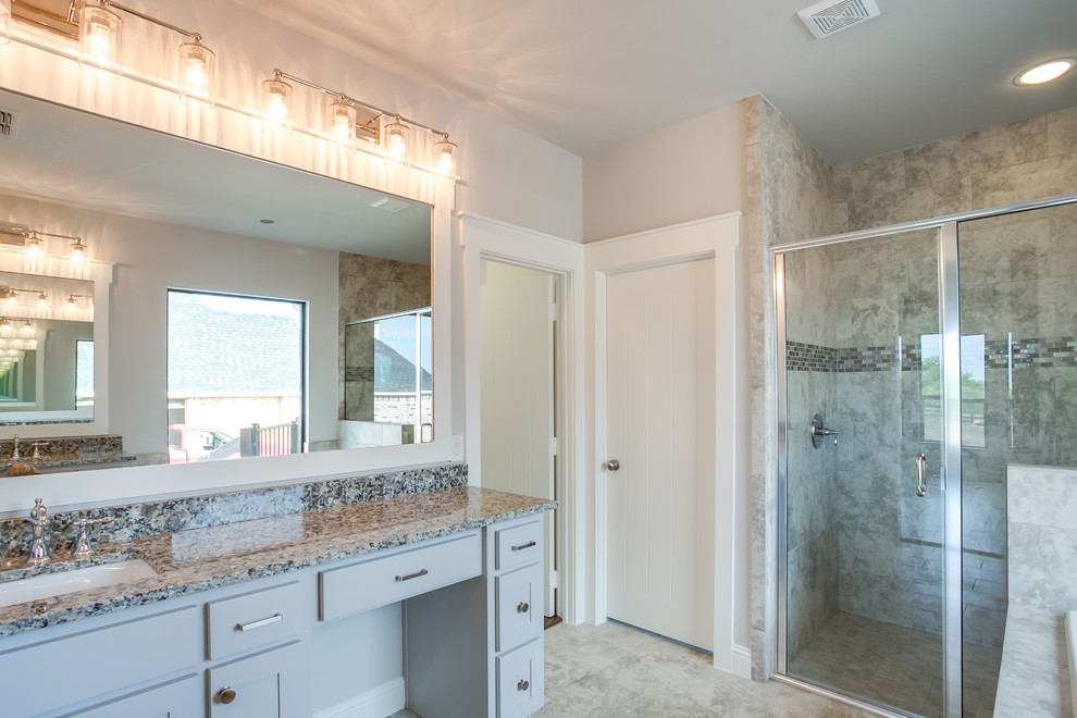 Large country master bathroom in Dallas with shaker cabinets, grey cabinets, a drop-in tub, an alcove shower, gray tile, ceramic tile, grey walls, ceramic floors, an undermount sink, granite benchtops, grey floor and a hinged shower door.