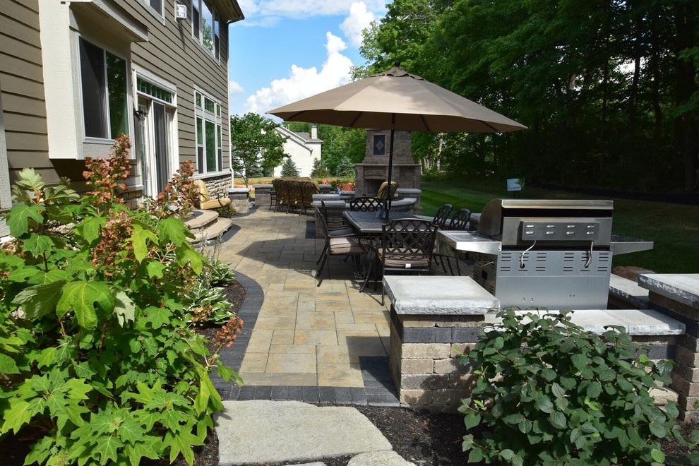 Inspiration for a large traditional backyard patio in Columbus with a fire feature and concrete pavers.