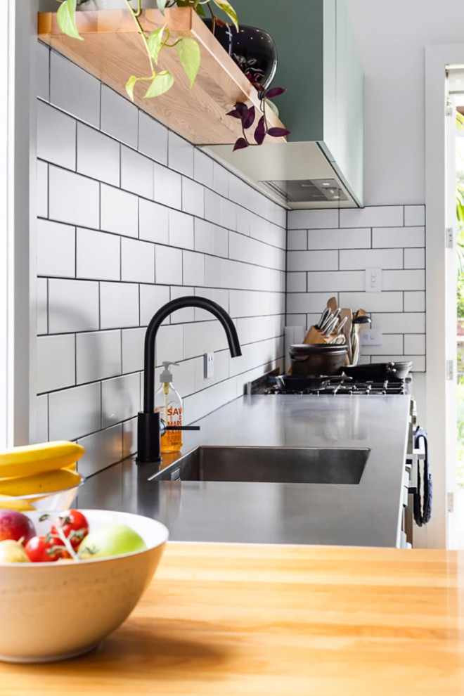 Offene, Zweizeilige, Mittelgroße Moderne Küche mit integriertem Waschbecken, flächenbündigen Schrankfronten, grünen Schränken, Küchenrückwand in Weiß, Rückwand aus Zementfliesen, Küchengeräten aus Edelstahl und Halbinsel in Auckland