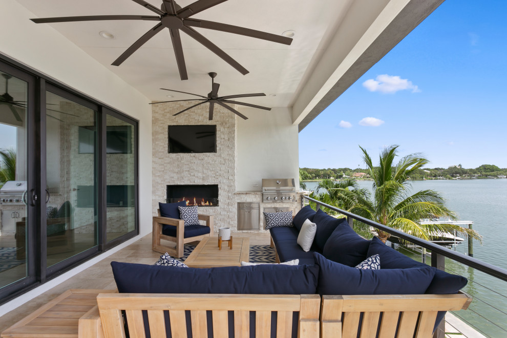 This is an example of a medium sized contemporary back wire cable railing veranda in Tampa with an outdoor kitchen, tiled flooring and a roof extension.