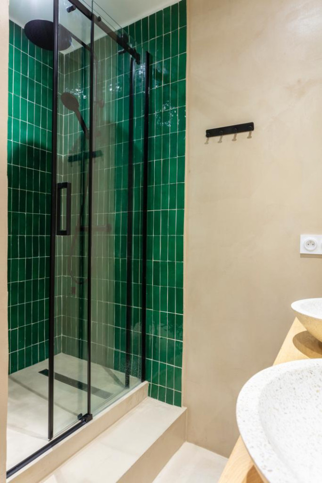 Design ideas for a mid-sized traditional master bathroom in Paris with light wood cabinets, a corner shower, a wall-mount toilet, green tile, subway tile, beige walls, concrete floors, a trough sink, beige floor, a sliding shower screen, a double vanity and a floating vanity.