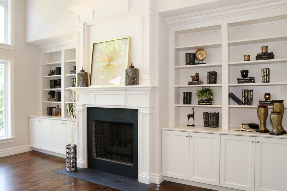 Photo of a large arts and crafts open concept family room in St Louis with grey walls, medium hardwood floors, a standard fireplace, a wood fireplace surround and brown floor.