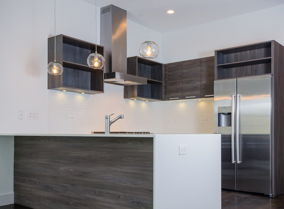 This is an example of a contemporary kitchen in Chicago with flat-panel cabinets, grey cabinets, quartz benchtops, white splashback, ceramic splashback, stainless steel appliances and dark hardwood floors.