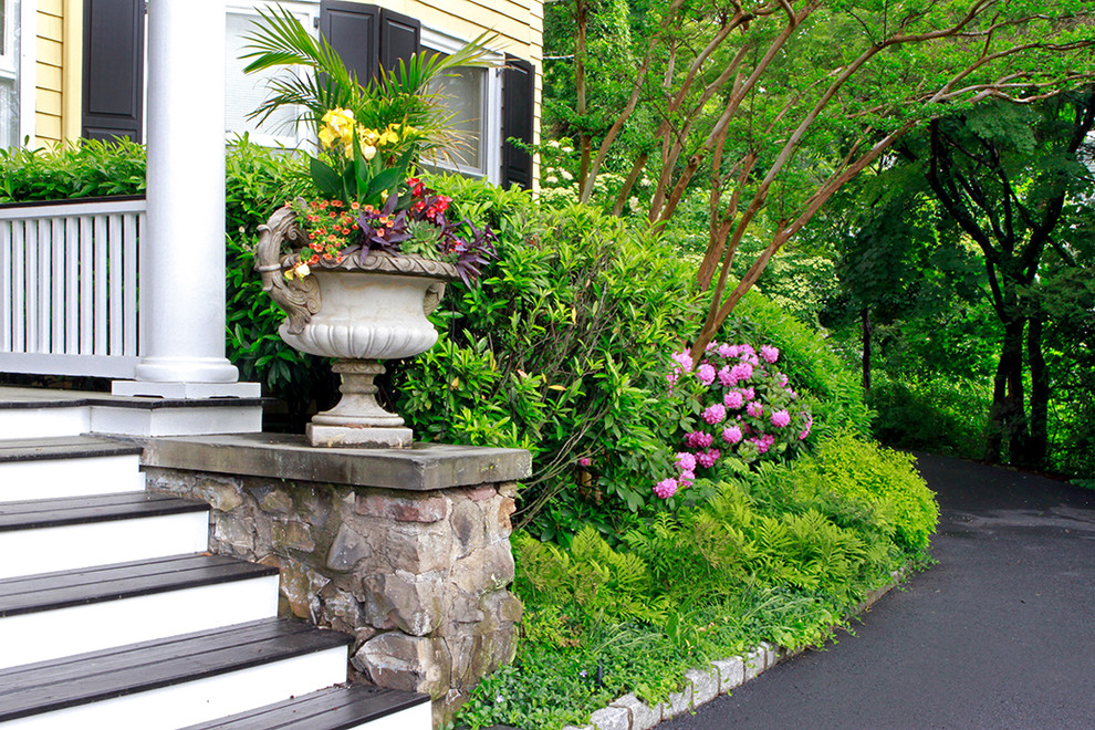 Large traditional front yard partial sun driveway in New York with a container garden and decking.
