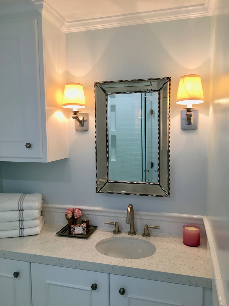 Photo of a small transitional bathroom in Santa Barbara with white cabinets, white tile, subway tile, blue walls, marble floors, an undermount sink and engineered quartz benchtops.