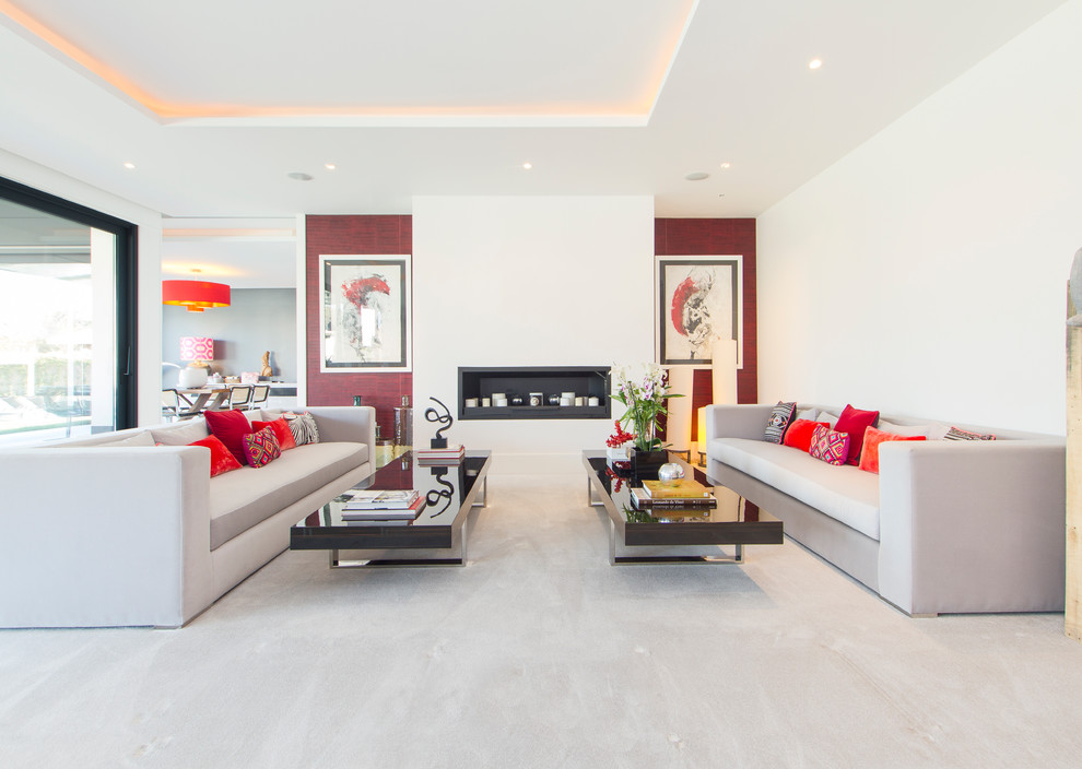 This is an example of a contemporary formal enclosed living room in Madrid with white walls, carpet, a ribbon fireplace, a metal fireplace surround and beige floor.