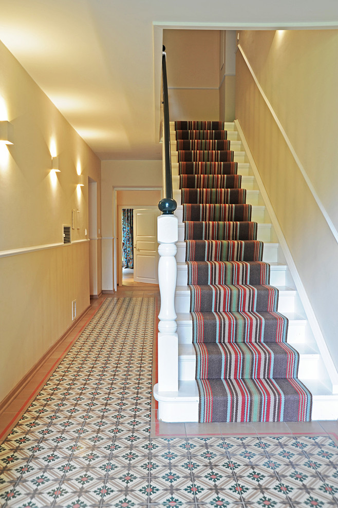 Example of a mid-sized country carpeted and multicolored floor hallway design with beige walls
