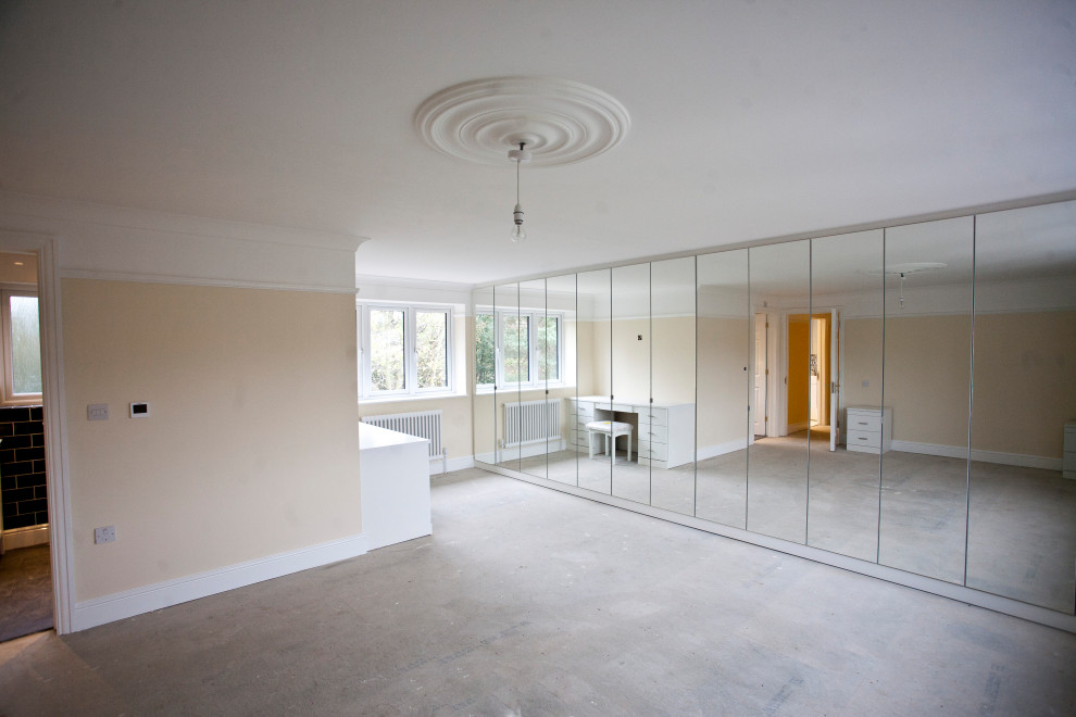 This is an example of an expansive classic master bedroom in Hertfordshire with carpet, no fireplace and grey floors.