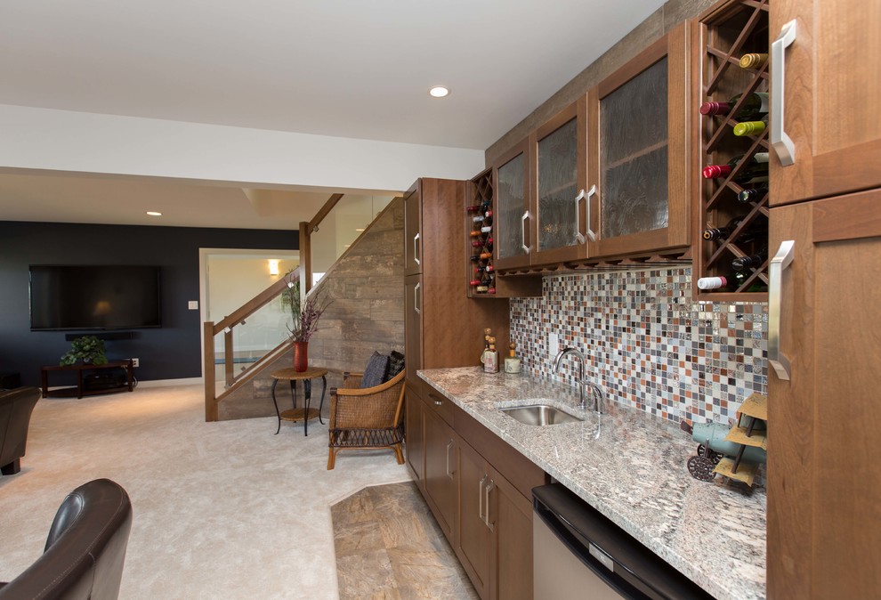 Large contemporary single-wall wet bar in Other with an undermount sink, granite benchtops, shaker cabinets, brown cabinets, multi-coloured splashback, glass tile splashback, carpet, beige floor and multi-coloured benchtop.