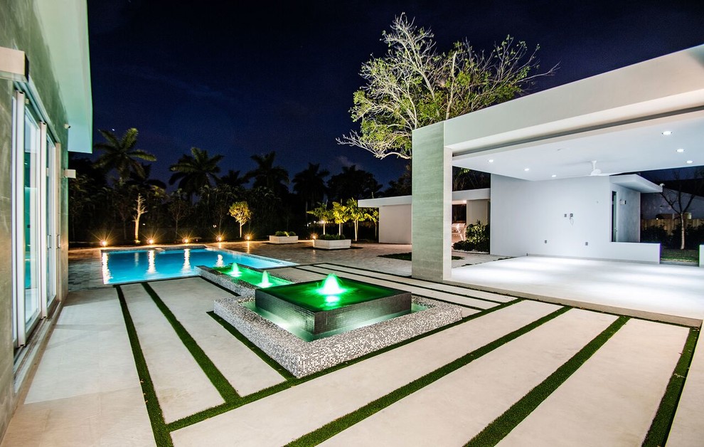 Inspiration for a large modern backyard rectangular lap pool in Orange County with a water feature.
