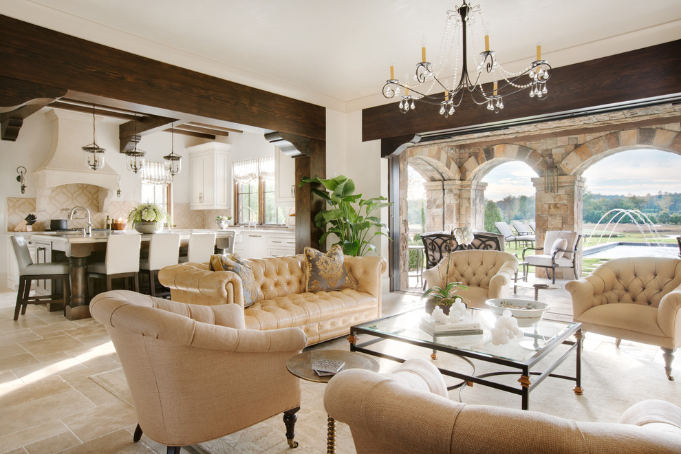 Photo of a large mediterranean open concept living room in Other with beige walls, limestone floors, a standard fireplace, a stone fireplace surround and a wall-mounted tv.