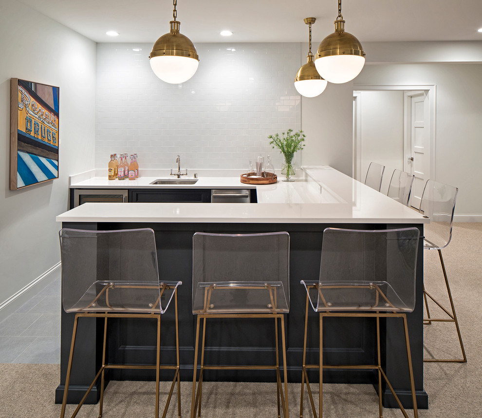 This is an example of a mid-sized transitional u-shaped seated home bar in Minneapolis with carpet, an undermount sink, recessed-panel cabinets, black cabinets and solid surface benchtops.