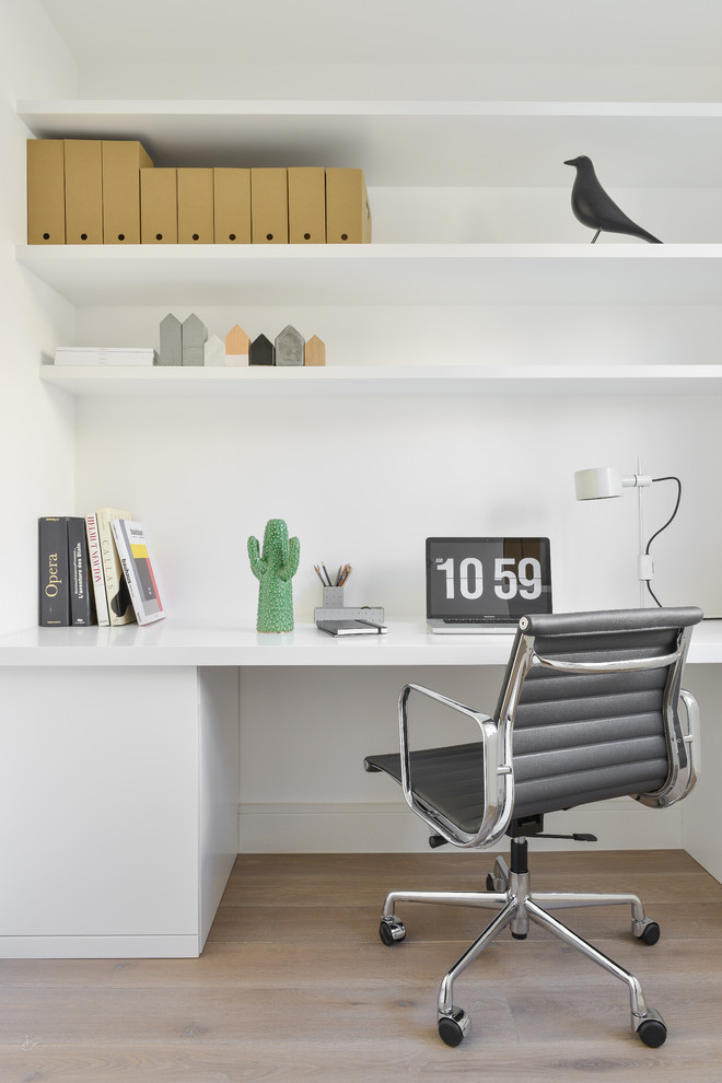 Scandinavian study room in London with white walls and a built-in desk.