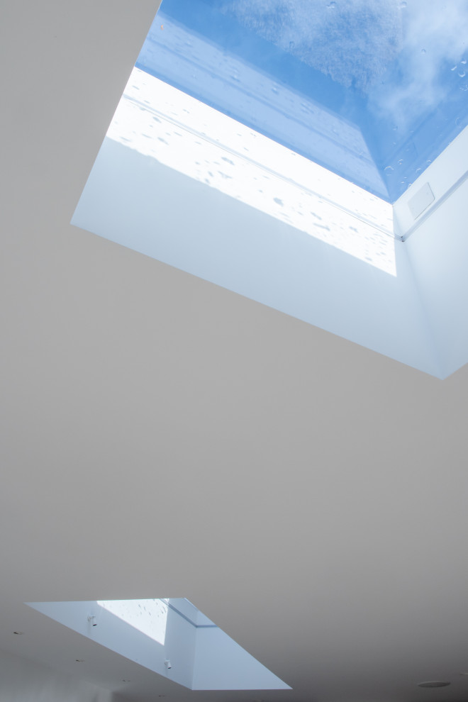 Design ideas for a medium sized contemporary open plan living room in Devon with white walls, porcelain flooring, no fireplace, a wall mounted tv and grey floors.