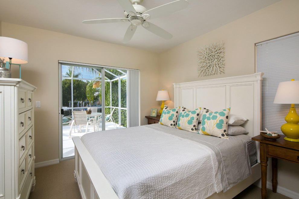 Design ideas for a beach style guest bedroom in Tampa with beige walls and carpet.