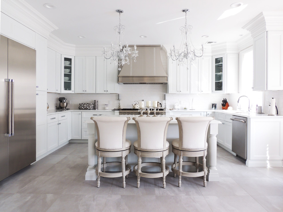 Design ideas for a large traditional l-shaped kitchen in New York with an undermount sink, white cabinets, granite benchtops, white splashback, ceramic splashback, stainless steel appliances, porcelain floors, with island, grey floor and recessed-panel cabinets.