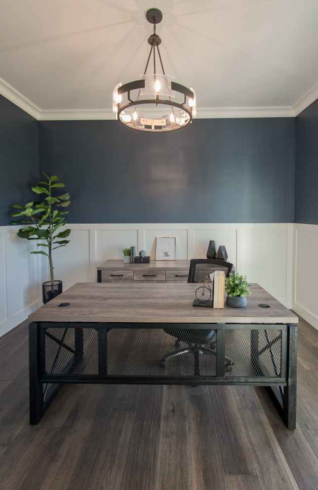 Пример оригинального дизайна: рабочее место в стиле неоклассика (современная классика) с синими стенами, паркетным полом среднего тона, отдельно стоящим рабочим столом, коричневым полом и панелями на стенах
