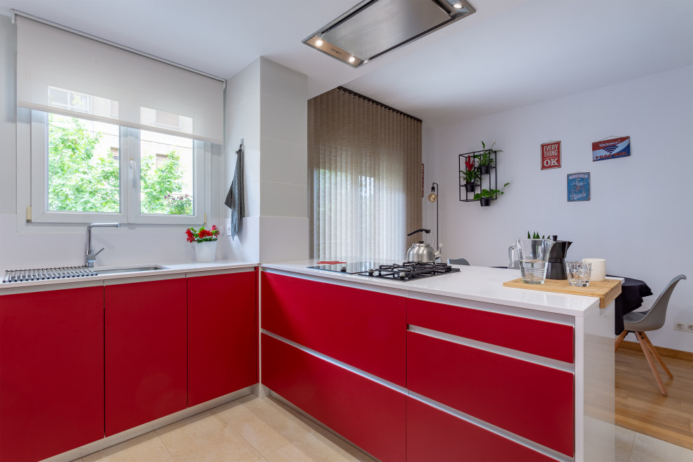 Inspiration for a mid-sized contemporary u-shaped open plan kitchen in Barcelona with a double-bowl sink, flat-panel cabinets, red cabinets, white splashback, stainless steel appliances, ceramic floors, a peninsula, beige floor and white benchtop.
