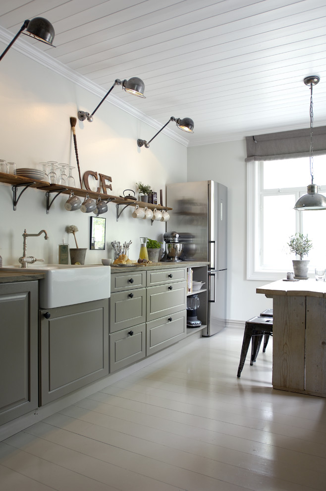 Photo of a country eat-in kitchen in Other with raised-panel cabinets, grey cabinets, stainless steel appliances, quartz benchtops and painted wood floors.