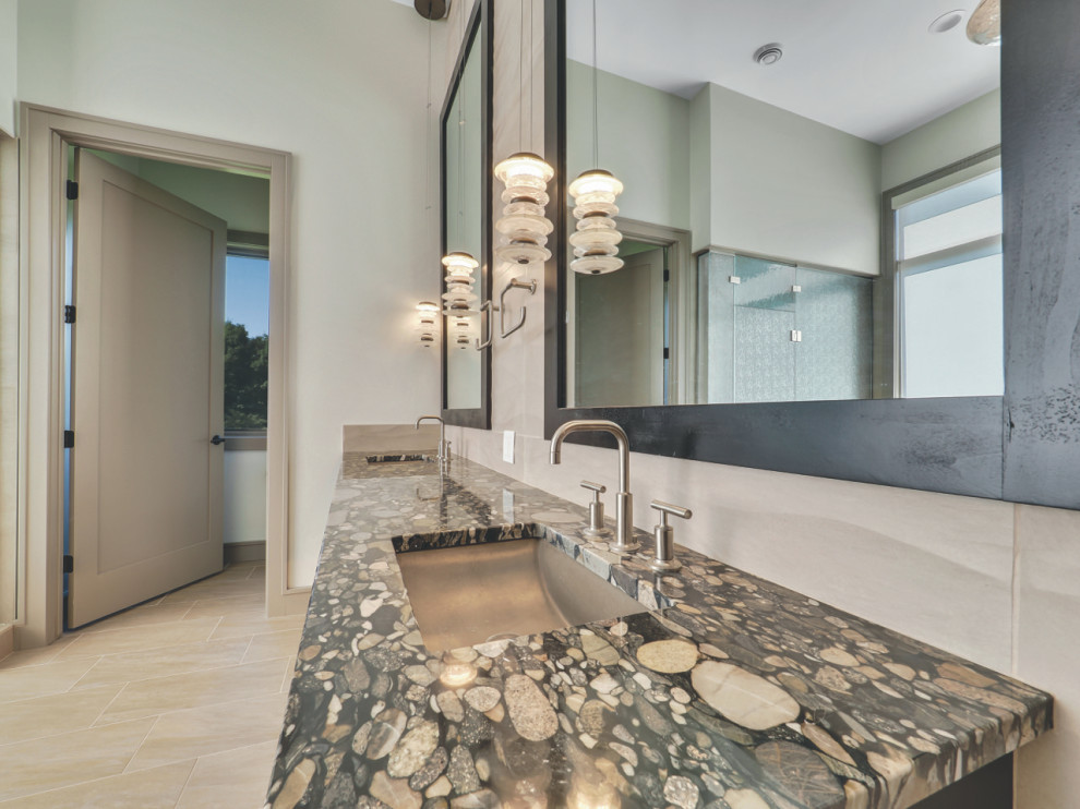 Example of a transitional beige tile and ceramic tile double-sink bathroom design with granite countertops and black countertops