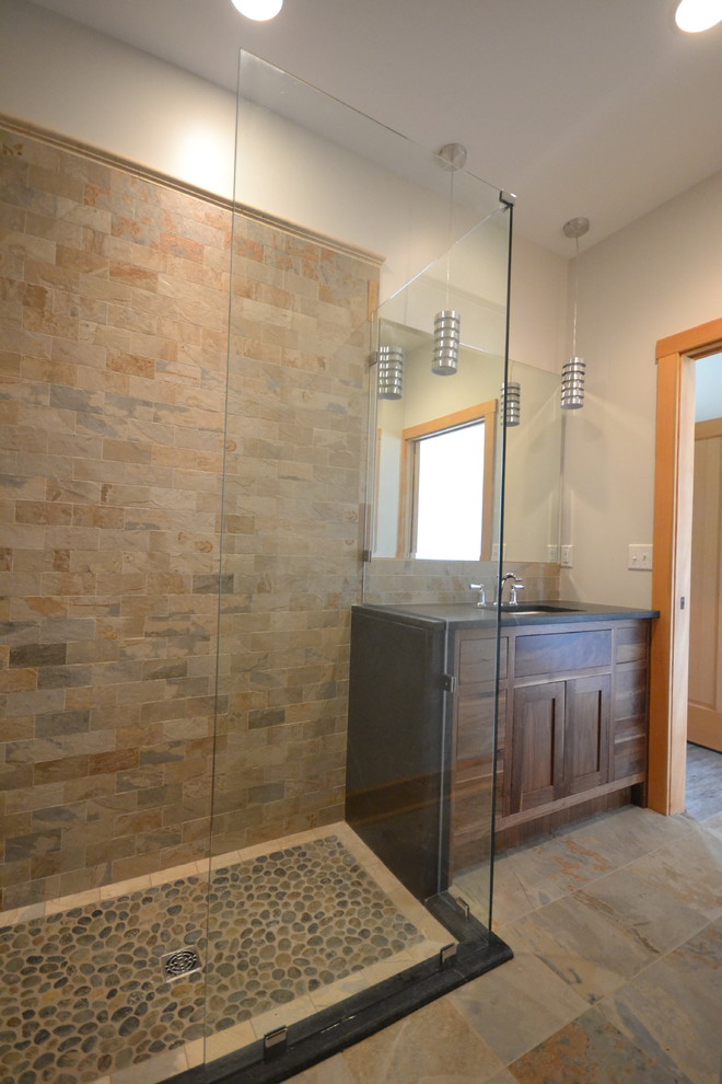 Photo of a mid-sized transitional master bathroom in Other with soapstone benchtops, a curbless shower, beige tile, porcelain tile, slate floors, brown floor and a hinged shower door.
