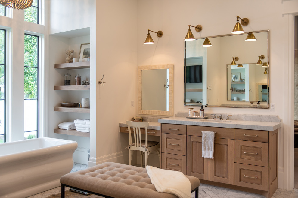 Inspiration for a country bathroom in Salt Lake City with recessed-panel cabinets, medium wood cabinets, a freestanding tub, white walls, an undermount sink, white floor and white benchtops.