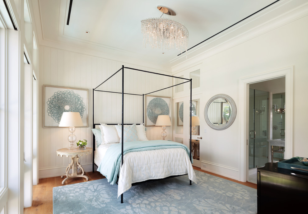 Inspiration for a beach style master bedroom in Miami with white walls and medium hardwood floors.