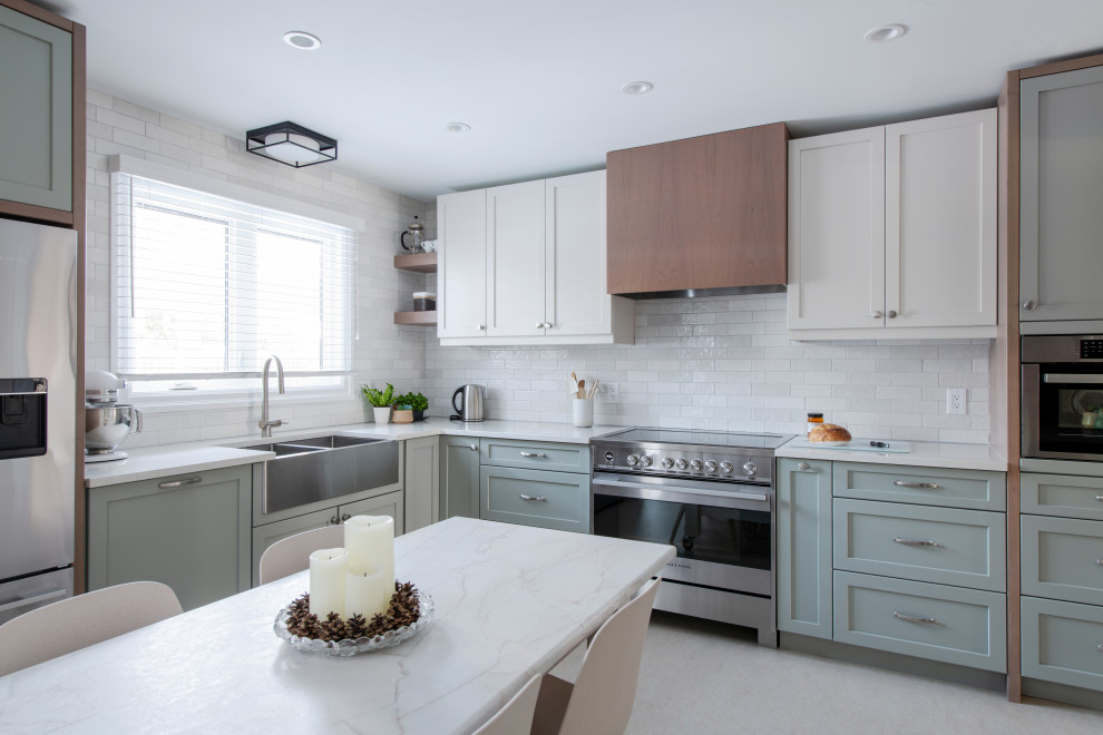 Inspiration for a mid-sized transitional u-shaped linoleum floor and gray floor eat-in kitchen remodel in Ottawa with a farmhouse sink, shaker cabinets, gray cabinets, quartz countertops, white backsplash, subway tile backsplash, stainless steel appliances, an island and white countertops