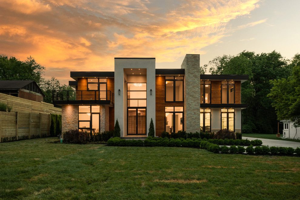 Imagen de fachada de casa multicolor y blanca minimalista extra grande de tres plantas con revestimiento de piedra y tejado plano