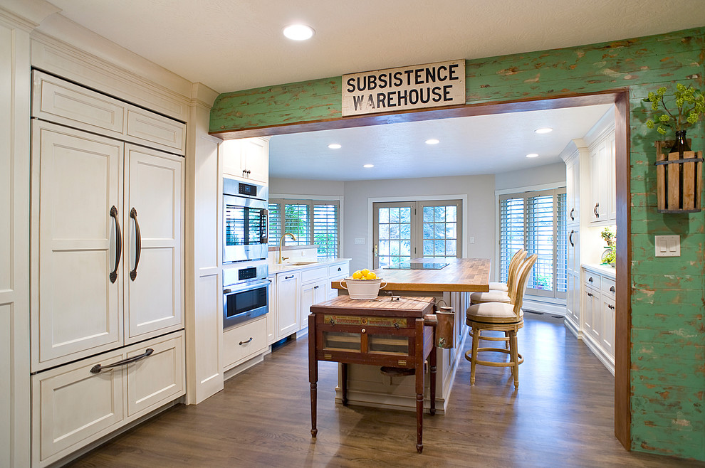 Eat-in kitchen - mid-sized transitional galley medium tone wood floor and brown floor eat-in kitchen idea with an undermount sink, recessed-panel cabinets, white cabinets, quartz countertops, paneled appliances and an island