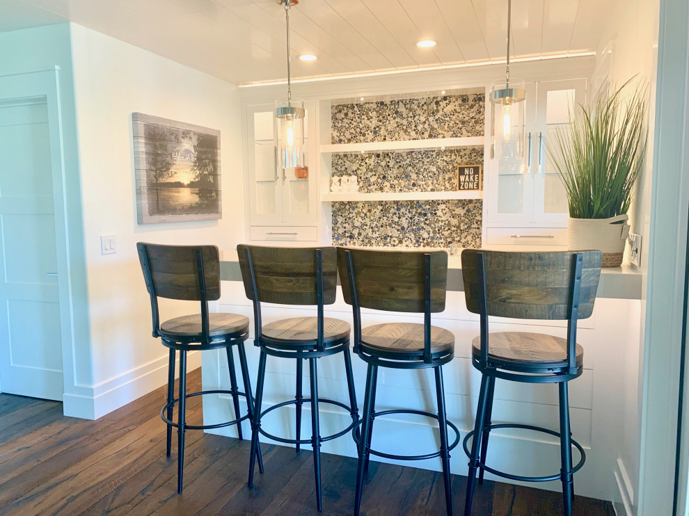 Photo of a mid-sized contemporary u-shaped seated home bar in San Diego with an undermount sink, glass-front cabinets, white cabinets, quartz benchtops, mosaic tile splashback, medium hardwood floors, brown floor and beige benchtop.