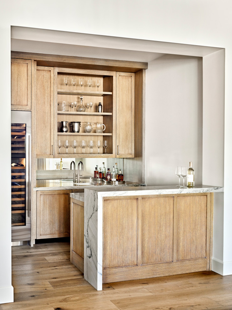 Inspiration for a mid-sized transitional galley medium tone wood floor and brown floor wet bar remodel in Phoenix with an undermount sink, recessed-panel cabinets, light wood cabinets, mirror backsplash and gray countertops