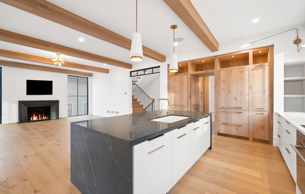 Open concept kitchen - large transitional u-shaped light wood floor and brown floor open concept kitchen idea in Chicago with an undermount sink, flat-panel cabinets, white cabinets, quartz countertops, white backsplash, porcelain backsplash, colored appliances, an island and black countertops