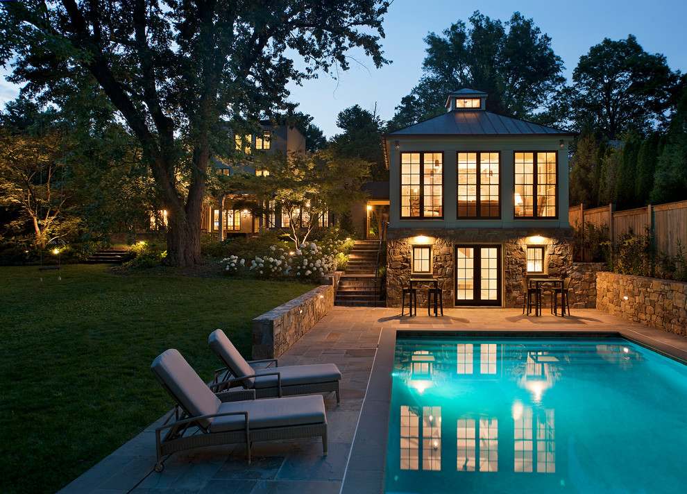 This is an example of a backyard rectangular pool in DC Metro with a pool house and natural stone pavers.
