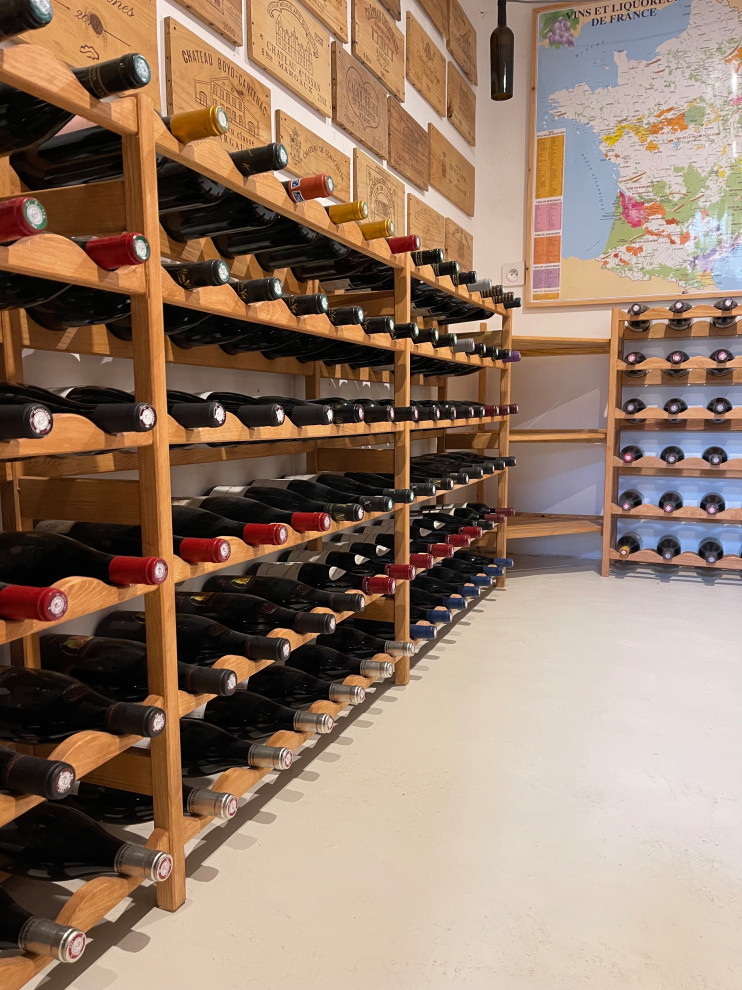 Mid-sized modern wine cellar in Other with concrete floors, display racks and white floor.