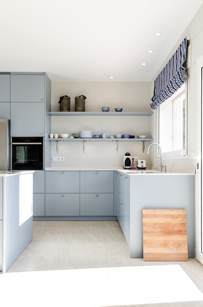 Design ideas for a mid-sized scandinavian l-shaped open plan kitchen in Malaga with flat-panel cabinets, blue cabinets and a peninsula.