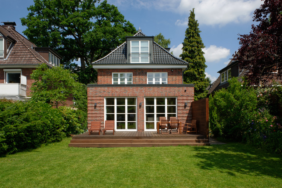 Mid-sized traditional two-storey brick brown house exterior in Hamburg with a hip roof and a metal roof.