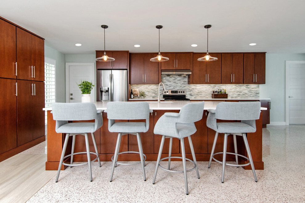 Inspiration for a medium sized midcentury galley open plan kitchen in Tampa with flat-panel cabinets, dark wood cabinets, engineered stone countertops, grey splashback, glass sheet splashback, stainless steel appliances, terrazzo flooring, an island and white worktops.