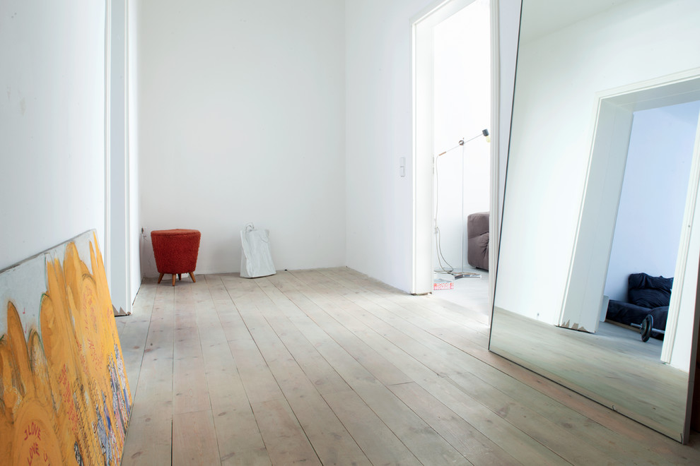 Photo of a mid-sized contemporary hallway in Berlin with white walls and light hardwood floors.