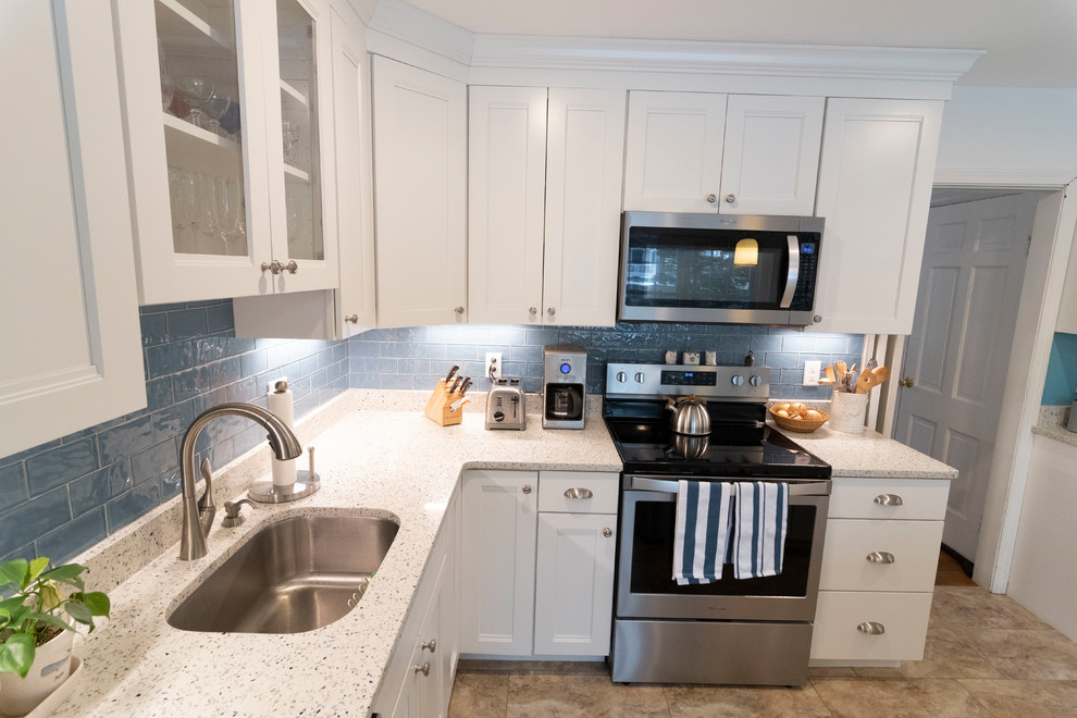 Example of a mid-sized transitional u-shaped beige floor enclosed kitchen design in Boston with an undermount sink, recessed-panel cabinets, white cabinets, blue backsplash, subway tile backsplash, stainless steel appliances, an island and beige countertops